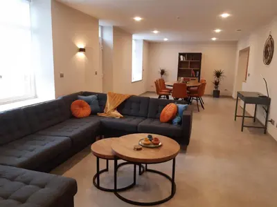 a living room with a blue couch and a table at De oude es in Bocholt