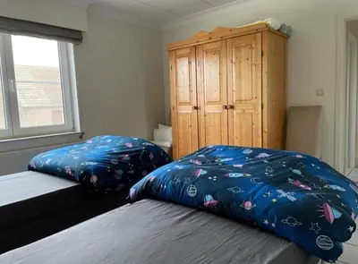a bedroom with two beds and a wooden cabinet at Het Damhert in Kortenaken