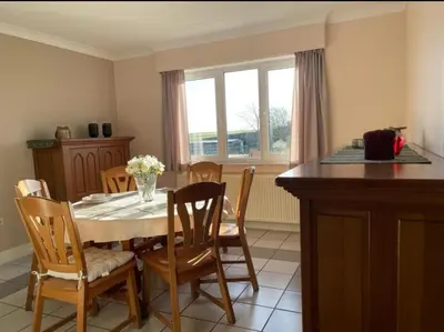 a dining room with a table and chairs and a window at Het Damhert in Kortenaken