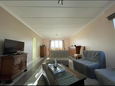 a living room with a couch and a tv at Het Damhert in Kortenaken