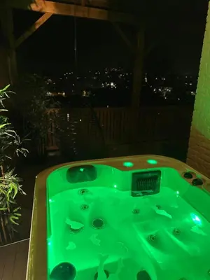 a green bath tub on a balcony at night at Suite Tino in Verviers
