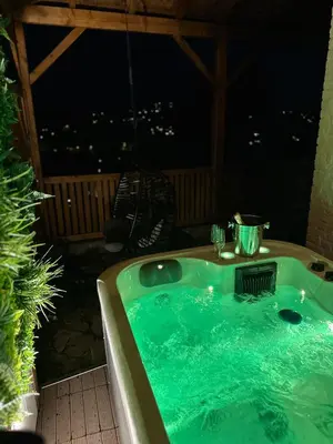 a jacuzzi tub on a patio at night at Suite Tino in Verviers