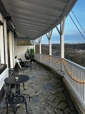 a patio with a table and chairs on a balcony at Suite Tino in Verviers