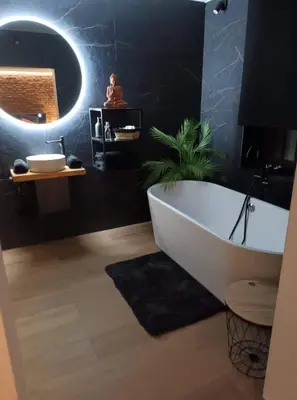a bathroom with a white tub and a plant at Suite Tino in Verviers
