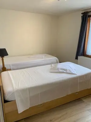 two beds in a room with white sheets at Vakantiewoning Wurfeldermolen in Maaseik