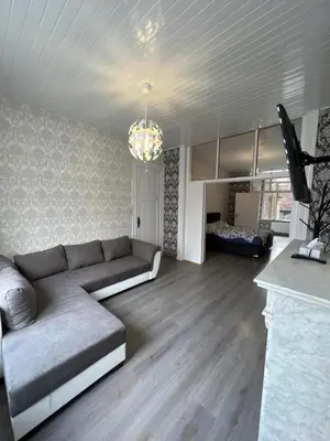 a living room with a couch and a tv in it at Proche de tout lieux touristiques à Liège in Liège