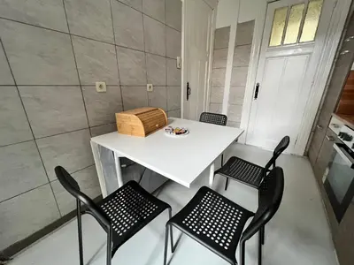 a small kitchen with a white table and chairs at Proche de tout lieux touristiques à Liège in Liège