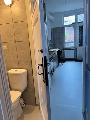 an open door to a bathroom with a toilet and a sink at Proche de tout lieux touristiques à Liège in Liège
