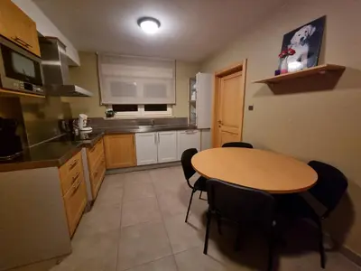 a kitchen with a wooden table and black chairs at Susberg 3 in Pelt