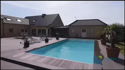 a large swimming pool in front of a house at Susberg 4 in Pelt