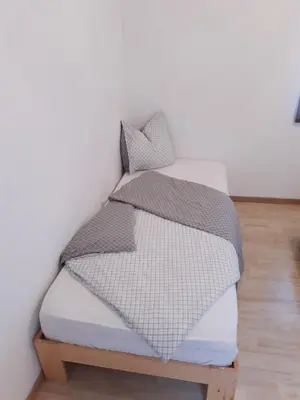 a bed with two pillows on top of it at Agréable maison avec cour à 10min de Liège in Herstal