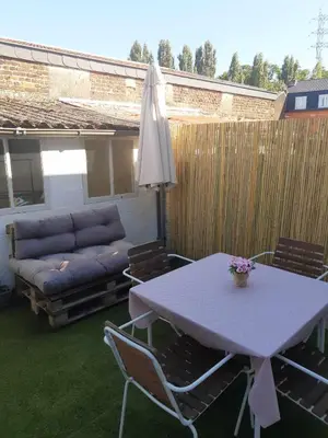 a patio with a table and a couch at Agréable maison avec cour à 10min de Liège in Herstal