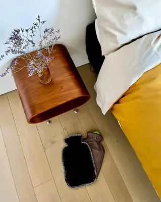 a table with a vase on it next to a bed at Huis van Hout - architectenwoning met grote panorama tuin - design hot tub optioneel in Herk-de-Stad