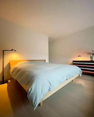 a bedroom with a white bed in a room at Huis van Hout - architectenwoning met grote panorama tuin - design hot tub optioneel in Herk-de-Stad