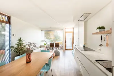 a kitchen and living room with a table and chairs at Huis van Hout - architectenwoning met grote panorama tuin - design hot tub optioneel in Herk-de-Stad