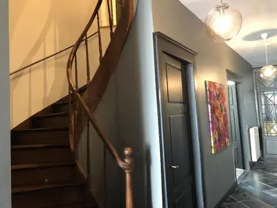 a hallway with a wooden staircase and a stair case at Gîte Jaja in Limbourg