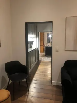 a living room with a mirror and a chair at Gîte Jaja in Limbourg