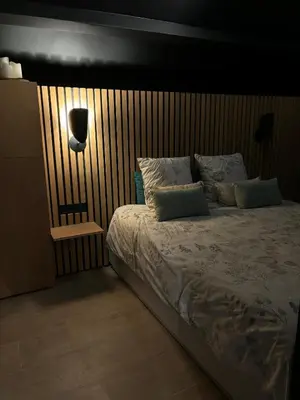 a bedroom with a large bed with a lamp on it at Le Makalle in Dalhem