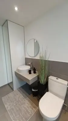 a bathroom with a white toilet and a sink at Le Makalle in Dalhem