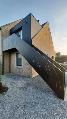 a metal slide in front of a building at Le Makalle in Dalhem