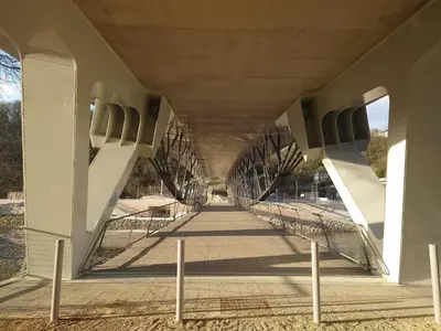 a walkway under a bridge with a person on it at La douce Rive in Esneux