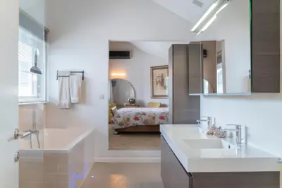 a bathroom with two sinks and a large mirror at Ruime woning met grote omheinde tuin in Hasselt