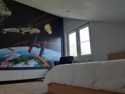 a bedroom with a wall mural of a space station at Ruime woning met grote omheinde tuin in Hasselt