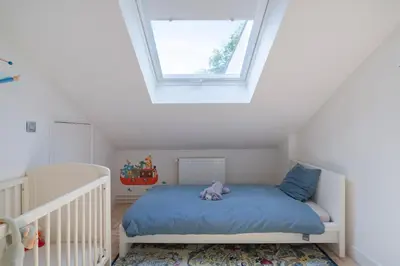 a small bedroom with a bed with a window at Ruime woning met grote omheinde tuin in Hasselt