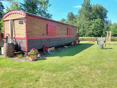 a wooden train car sitting in a field at Margaux B&B Babbita in Stokrooie
