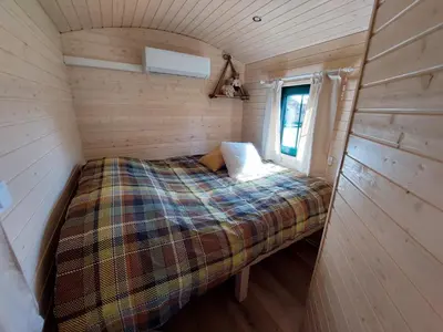 a bed in a small room in a tiny house at Pia B&B Babbita in Hasselt