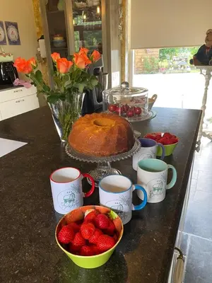 a kitchen counter with a cake and bowls of strawberries at Pia B&B Babbita in Hasselt