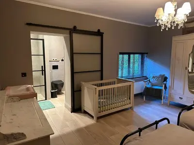 a living room with a crib in a room at de Kegelhoeve in Zonhoven