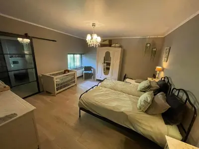 a bedroom with a bed and a crib in it at de Kegelhoeve in Zonhoven