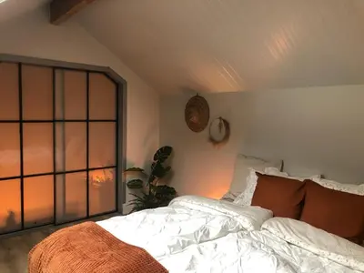 a bedroom with a bed and a window at de Kegelhoeve in Zonhoven