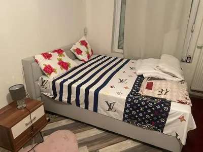 a small bedroom with a bed with a striped blanket at Belle appartement sur liège in Liège