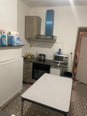 a small kitchen with a white table and a stove at Belle appartement sur liège in Liège