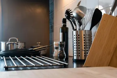 a kitchen counter with utensils and a container of utensils at Saint Pablo Boutique Apt I 3BR, Grote Markt, City Center, Near Station in Hasselt