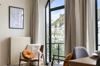 a living room with a window with a view of a city at Saint Pablo Boutique Apt I 3BR, Grote Markt, City Center, Near Station in Hasselt