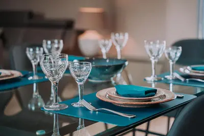 a table with wine glasses and plates on it at Cour 44 - Gite de charme avec sauna et jacuzzi in Remicourt