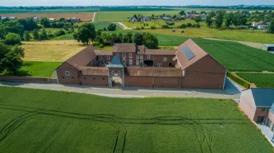 an aerial view of a large building in a field at Cour 44 - Gite de charme avec sauna et jacuzzi in Remicourt