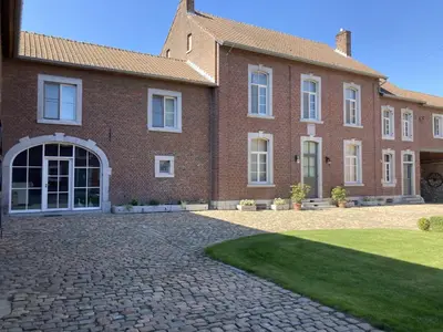 a large brick house with a brick driveway at Cour 44 - Gite de charme avec sauna et jacuzzi in Remicourt