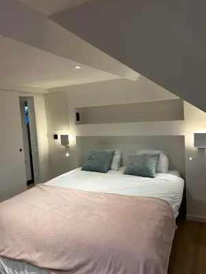 a bedroom with a large bed with two pillows at Ô Colombages in Les Biolles