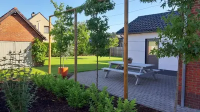 a patio with a picnic table in a garden at Huize Clementina in Peer