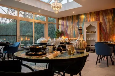 a dining room with a table with a vase on it at B&B 1001 nacht in Zonhoven