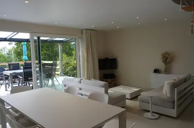 a living room with white furniture and a large window at Holiday Home Mooi-Gemmenich in Plombières