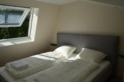 a bed with two pillows on it next to a window at Holiday Home Mooi-Gemmenich in Plombières