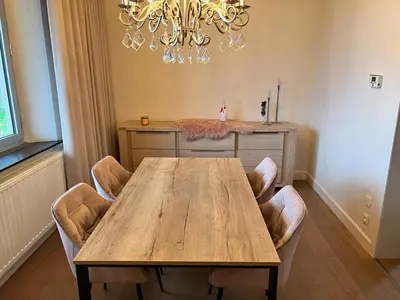 a dining room table with chairs and a chandelier at R&M in Kortessem