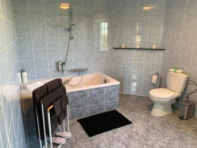 a bathroom with a bath tub and a toilet at R&M in Kortessem