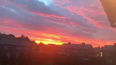 a sunset over a city with houses and buildings at R&M in Kortessem