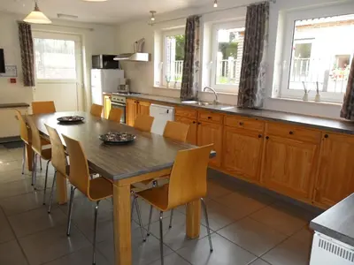 a kitchen with a wooden dining table and chairs at Schophemmerhoeve in Voeren